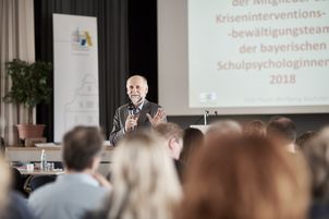 Ein Referent spricht in der Aula der ALP vor Publikum
